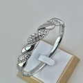 Silver twisted bangle with pavé crystals and 18K gold plating on a jewelry stand - Full Diamond Twisted Silver Bangle