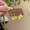 Detail showing handmade osmanthus flower earrings with white pearls on a wood stand - Yellow Translucent Flower Artificial Pearl Earrings (7998)