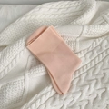 Peach pink mid-calf cotton socks displayed on a cream cable knit textured blanket - Pink