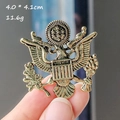 Detail of vintage bronze eagle brooch with shield design showing 4x4.1cm size and texture - Badge