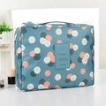 Travel cosmetic bag with blue fabric and pink floral patterns on a white surface - Light Blue Floral