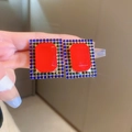 Detailed view of vintage gold earrings with large red resin stones and blue-green rhinestones - Silver Needle - Red Square Stud Earrings