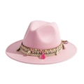 Detail eines rosa Wollfilzhutes mit gewebtem Band, Muscheln und bunten Quasten - Rosa
