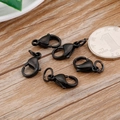 Set of five black metal lobster clasps for DIY jewelry making on a light wood background - 15mm / Black