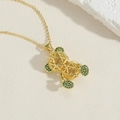 Détail du pendentif ours évidé plaqué or 14K avec zircons verts sur une chaîne dorée - Or/Zirconium Vert