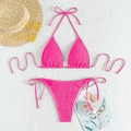 Flat lay of rose red smocked bikini set with straw hat and sunglasses on white sand - Rose Gold