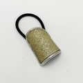 Detail eines hochelastischen Pferdeschwanzhalters mit funkelndem goldglitzerndem Dekor - Silber