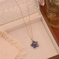 Detail of star-shaped natural stone pendant on gold stainless steel chain in tray - 5# Blue Vein