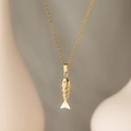Close-up of golden fish pendant featuring textured scales and a tiny red gemstone eye - Champagne Gold Koi