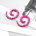 Detail of pink acrylic spiral ear gauges with black star patterns on white display card - Pink Star / 4mm