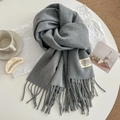 Elegant grey faux cashmere scarf with tassels and brand label on a white table - 200cm / Medium Grey