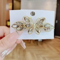 Eleganter Schmetterlings-Haarclip in Champagner-Kristall und Gold auf Displaykarte - Grau
