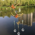 Moon dream catcher with monarch butterflies, green crystal, and glass balls hanging over water - Green Fluorite