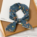 Gray-blue linen floral hair scarf tied in a bow on a stylish wooden display tray - Vine Blue Base
