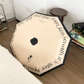Französischer Vintage Sonnenschirm in Beige mit Blumendekor und schwarzer Umrandung - Französischer Retro-Buchstaben-Stil