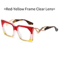 Cat eye zonnebril met rood-geel verloopmontuur en golvende gouden pootjes - Rood Geel Montuur Helder Glas