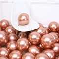 Glossy rose gold metallic balloons scattered by a white chair for party decorations - 12 Inch 2.8g Metallic Rose Gold 50Pcs