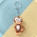 Close-up of a cute cartoon monkey keychain with large eyes and a white heart detail - Monkey