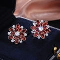 Exquisite ruby and white zircon sunflower earrings displayed on a dark blue velvet box - Silver & Red