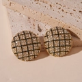 Close-up of vintage gold stud earrings with crystal checkered patterns on stone - Gold