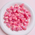 Close-up of pink iridescent bow-shaped acrylic beads arranged in a white decorative tray - Sold per piece / Rose Red