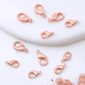 Macro shot of 18K rose gold lobster clasps for DIY jewelry making on marble surface - 12mm / Rose Gold