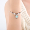 Silver snake chain bracelet with evil eye pendant and sparkling stones on a wrist - Oil Drip Evil Eye Style (E439) / Steel