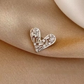 Élégante broche en forme de cœur avec zircons étincelants sur fond de tissu beige - Style Cœur Argenté (0261)