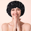 Detail of black double-layered satin waterproof shower cap with elastic band on model - Black