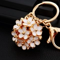 Golden flower ball keychain with white enamel petals and secure lobster clasp charm - White Hollow Flower Ball