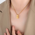 Elegant gold titanium steel necklace with rectangular letter W pendant on a female model - Letter W Style (P1506-W)