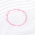 Detail of a handmade pink seed bead bracelet on a textured white fabric background - Hot Pink