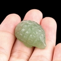Mini green amethyst hedgehog crystal carving figurine displayed on a human palm - Green Aventurine