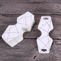 White cardboard jewelry display card with black geometric patterns on a wood surface - Black Geometric Lines
