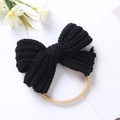 Detail of a textured black knitted bow with a soft nylon baby headband on a white background - Black