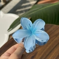 Close-up of translucent ice blue plumeria hair claw clip with shimmering glitter finish - Plumeria Jelly Texture / Ocean Blue