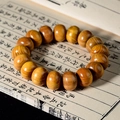 Gros plan de perles de prière en bois de santal sur fond de livre ancien culturel - Bois de santal doré / 16mm x 18 Pcs