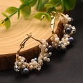 Macro view of handmade gold hoop earrings with white pearls and blue gemstones - Black Pearl Hoop Earrings