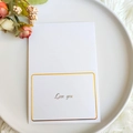 Elegante biglietto bianco con testo dorato Love You su piatto bianco per regalo - Ti Amo