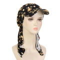 Detailed view of floral pattern printed on black fabric turban cap with head tie strap - Black Yellow Flowers