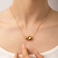 Macro view of gold minimalist twisted geometric pendant on a delicate snake chain - Twisted Geometric Style (N0205)