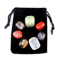 Polished hexagonal crystal stones in seven colors placed on a black velvet drawstring bag - Red Agate Rainbow Tumbled Stone Set With Velvet Bag