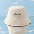 Minimalist beige bucket hat with black lsrg embroidery on blue wooden background - M / Beige