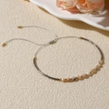 Detailed shot of handmade woven bracelet with pink natural stones and adjustable grey cord - Grey/Multicolor