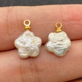 Ciondolo in perla naturale a forma di fiore con occhiello dorato tenuto sulle dita - Fiore a Cinque Petali 11x15mm