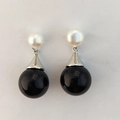 Elegant drop earrings featuring a white freshwater pearl and a large glossy black bead - Black