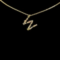 Golden 18k necklace with colorful zircon letter pendant on a sleek black background - Letter W / Gold