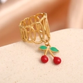 Close-up of gold hollow ring featuring red cherry pendant on stone background - Interlaced Oval Style (J-2009)