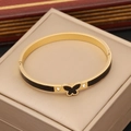 Dettaglio del bracciale dorato con farfalla nera e zirconi su scatola da gioielli - Nero