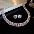 Detailed close-up of pink gemstone jewelry set with rhinestones and silver metal - Pink